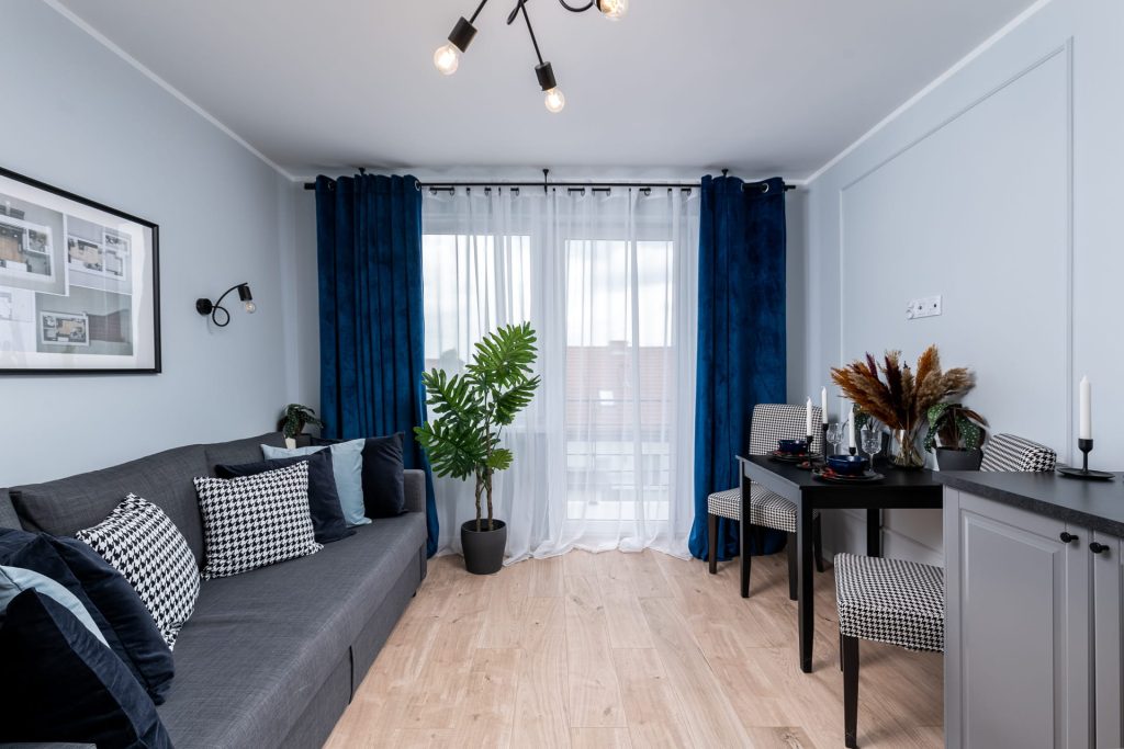 Nowa Przestrzeń – wnętrze mieszkania przy ulicy Grębałowskiej w Krakowie, salon z widokiem na balkon i częścią jadalnianą