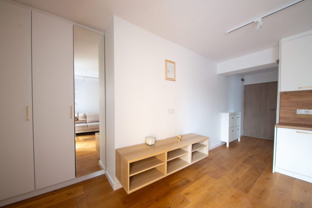 Nowa Przestrzeń – wnętrze mieszkania przy ulicy Pleszowskiej w Krakowie, salon z aneksem kuchennym i balkonem